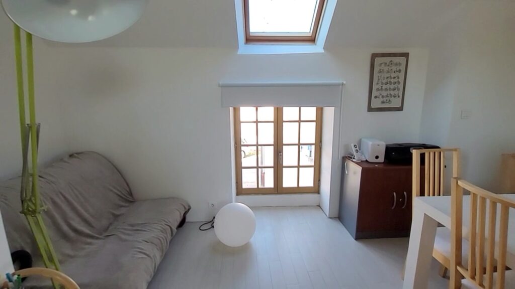 Salon de l'appartement, avec second canapé, fenêtres et table à manger